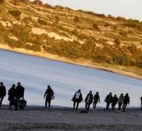 Migrants walk away from camp